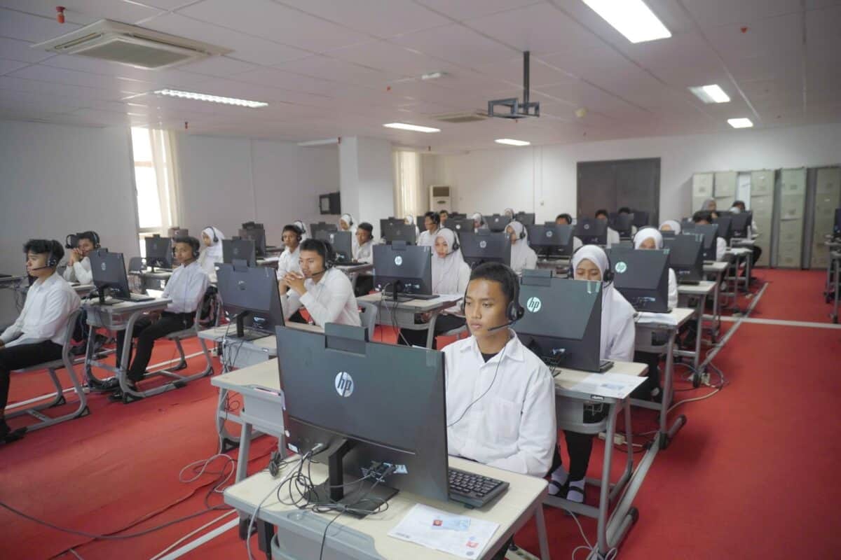 Peserta asesmen bahasa Inggris IPDN menggunakan komputer dan headset.